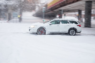 白昼雪地上的白色轿车